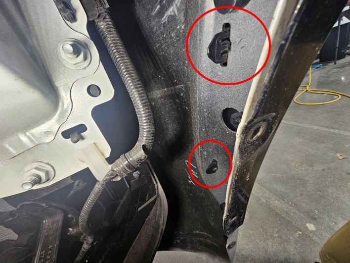 Two fender flare clips marked behind the fender liner